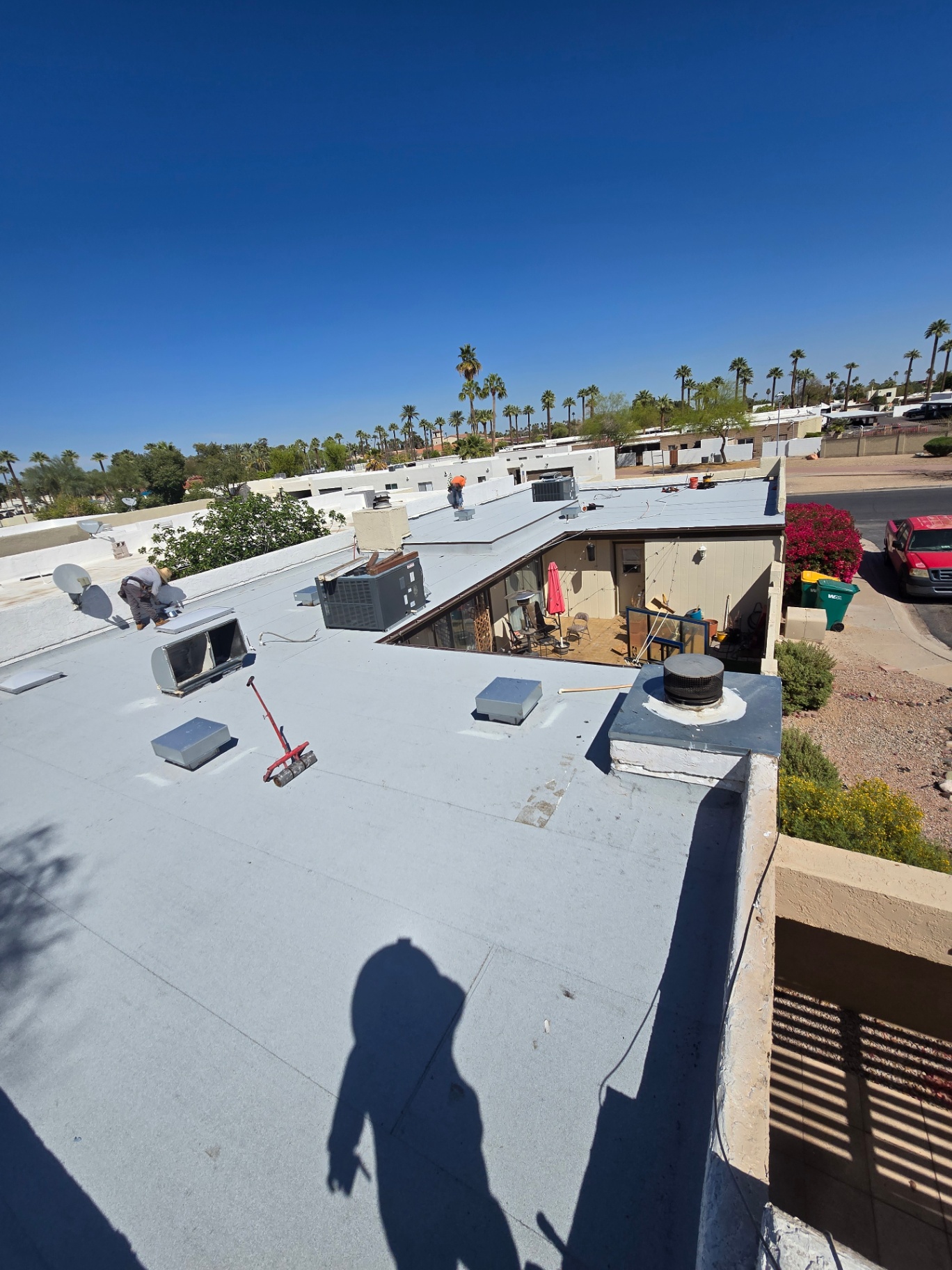 Multi-level flat roof with fresh white reflective coating between tile sections