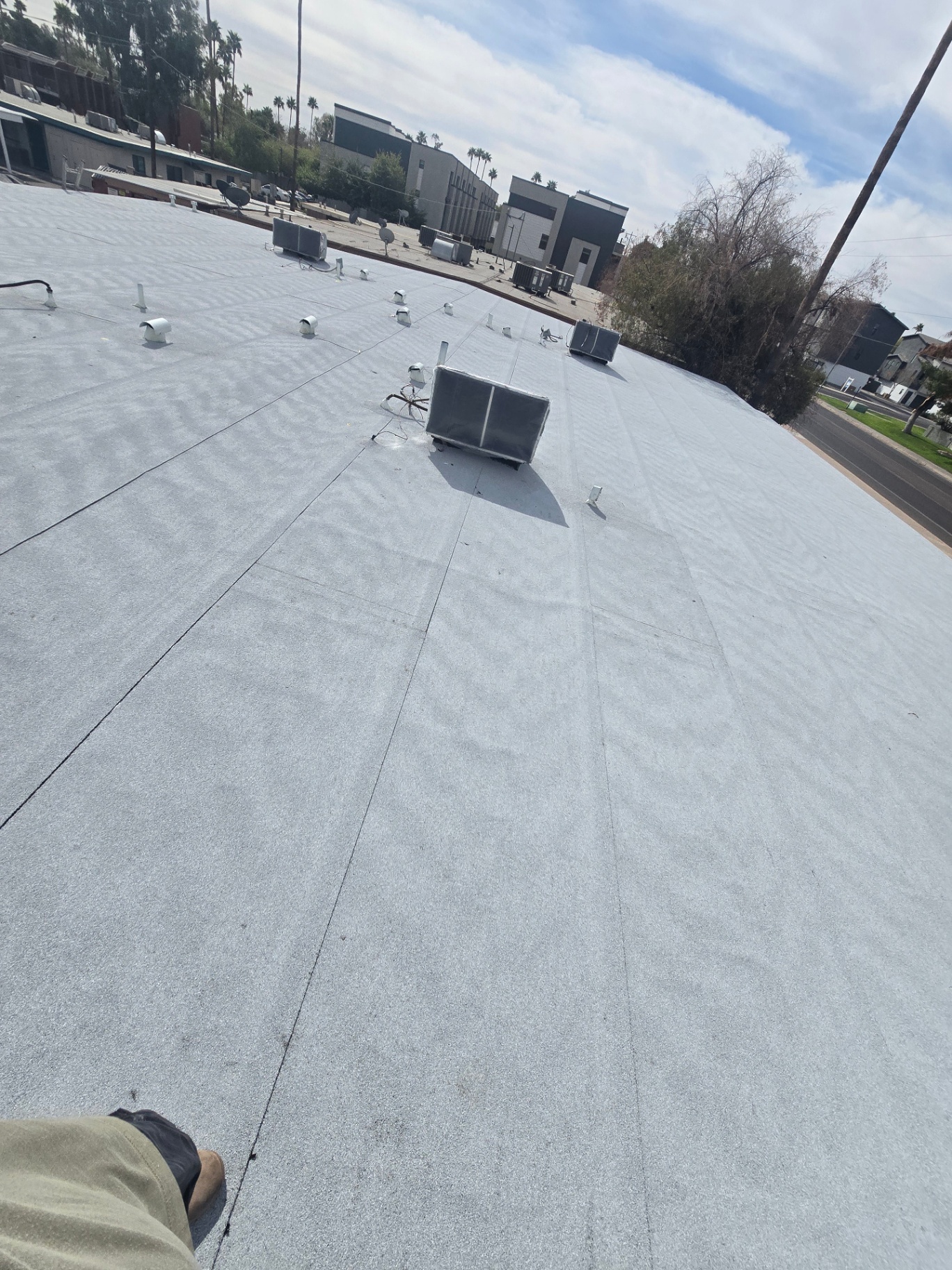 Large commercial flat roof finished with reflective granulated cap sheet