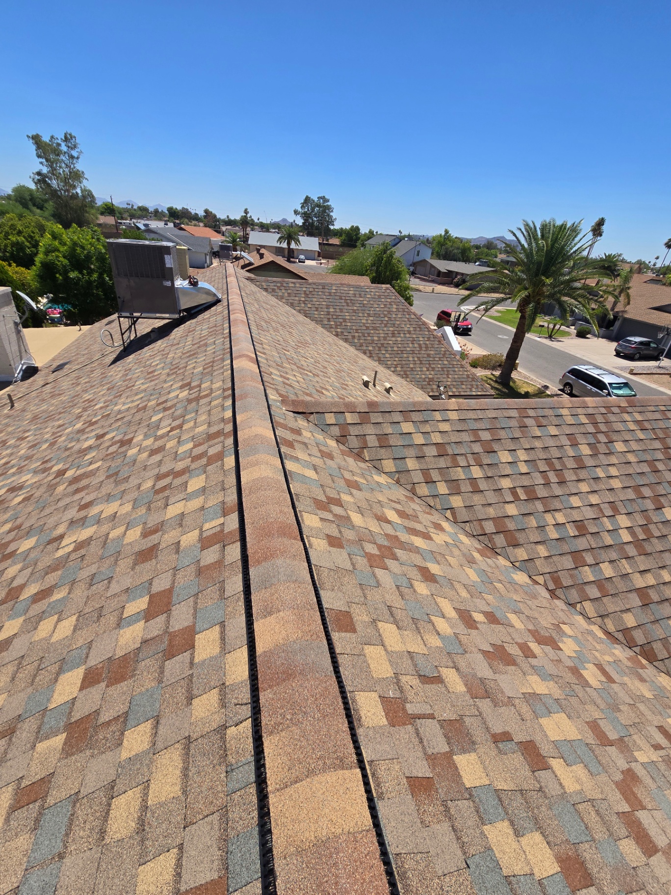 Earth-tone designer shingle roof with continuous ridge ventilation