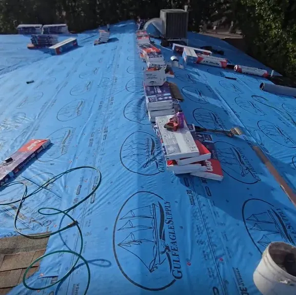 Roof Doc shingle roof installation in progress over blue underlayment