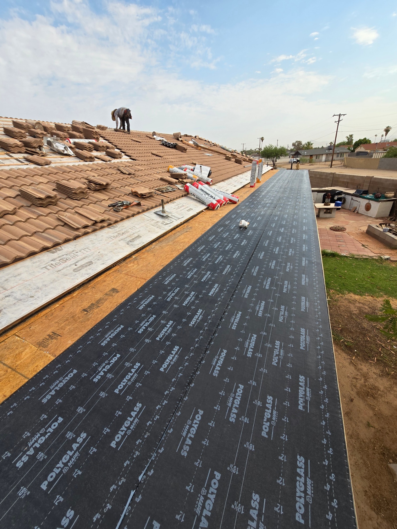 Patio roof underlayment installed alongside tile roof tear-off in progress